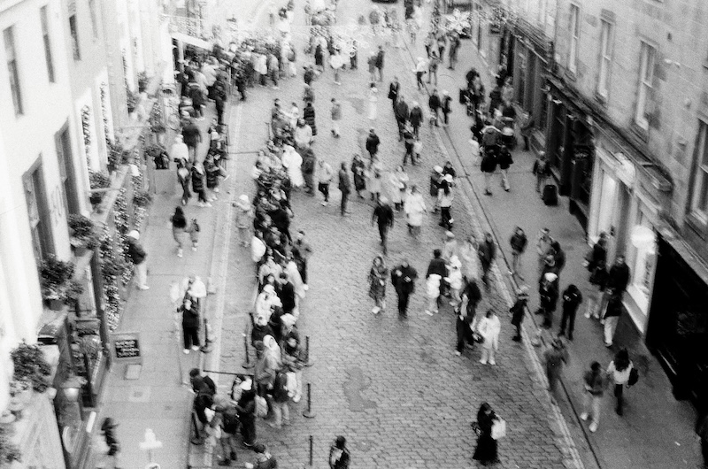 People walking over Victoria street in Edinburgh